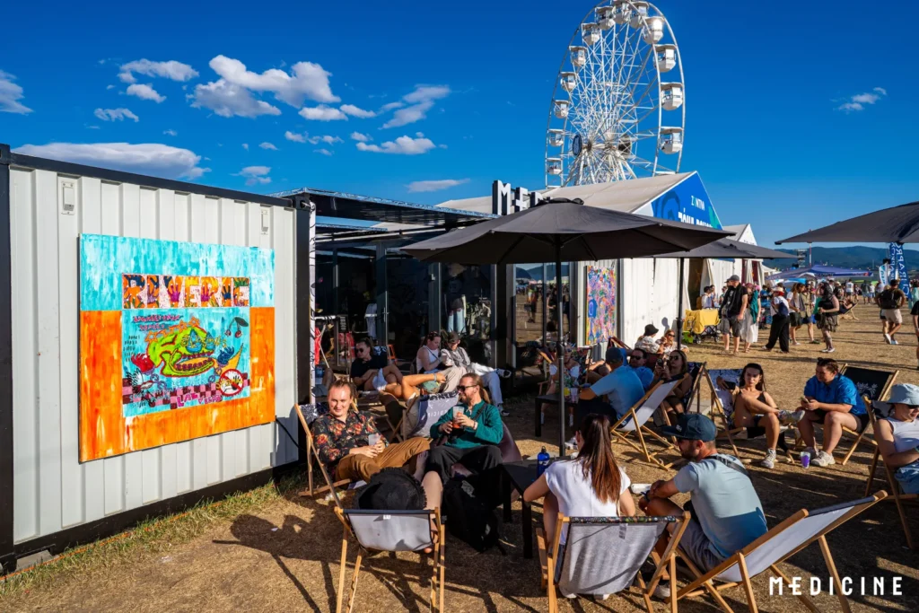 Farebné street-artové plátno na kontajneri zóny Medicine na Pohode a chillout s ležadlami, v pozadí festivalové koleso