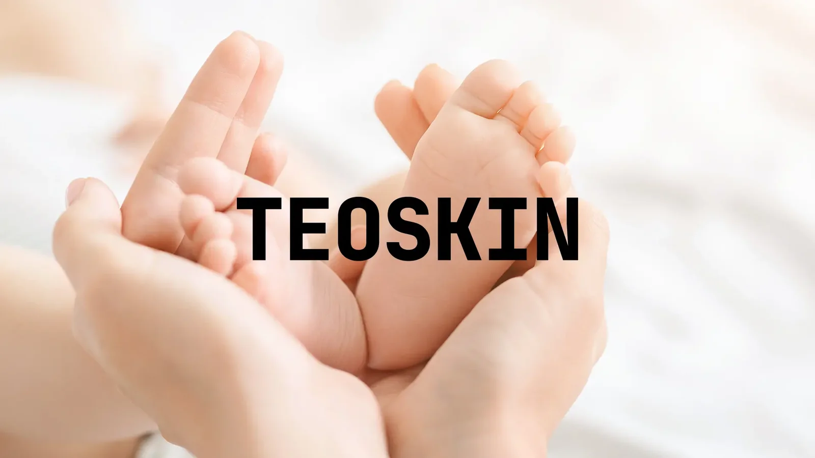 Logo TEOSKIN na fotografii dětských nožiček v dlaních rodiče